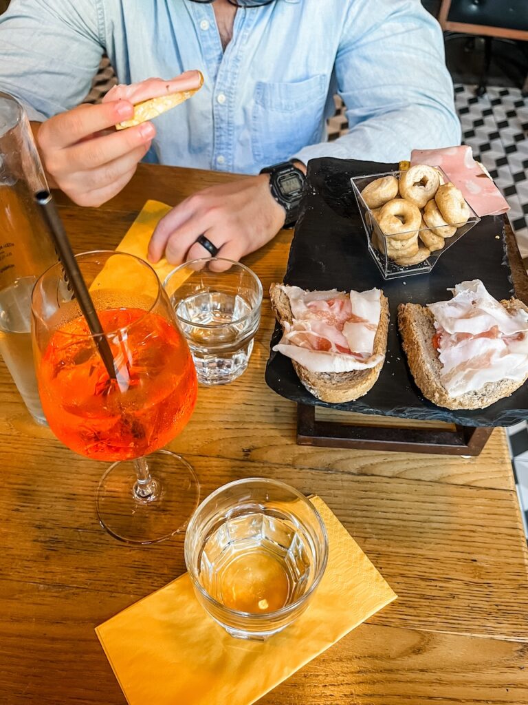 Couple enjoys an aperitivo of Aperol Spritz and Italian snack foods