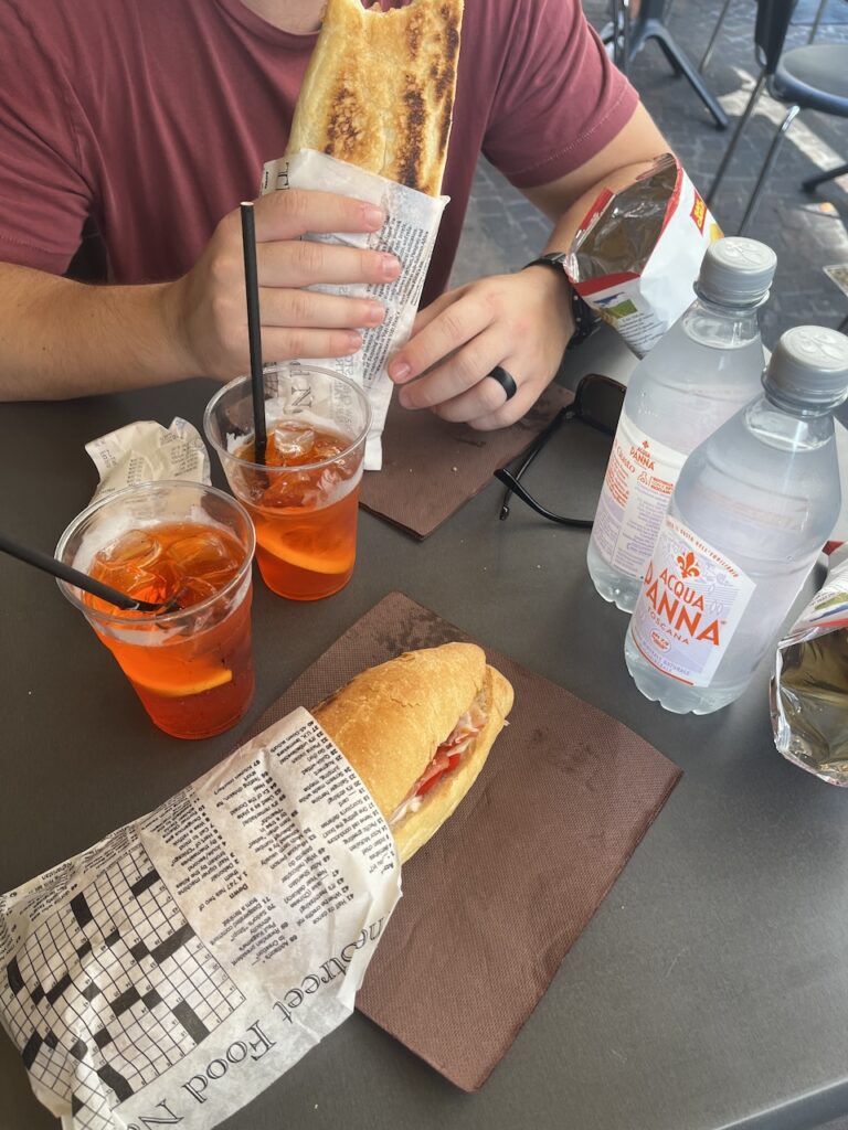 Couple enjoys a lunch of Aperol Spritz and Italian sandwiches