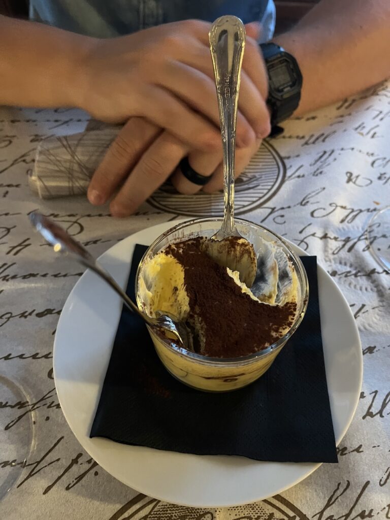 Cup of half eaten Tiramisu sits on a table in Venice Italy