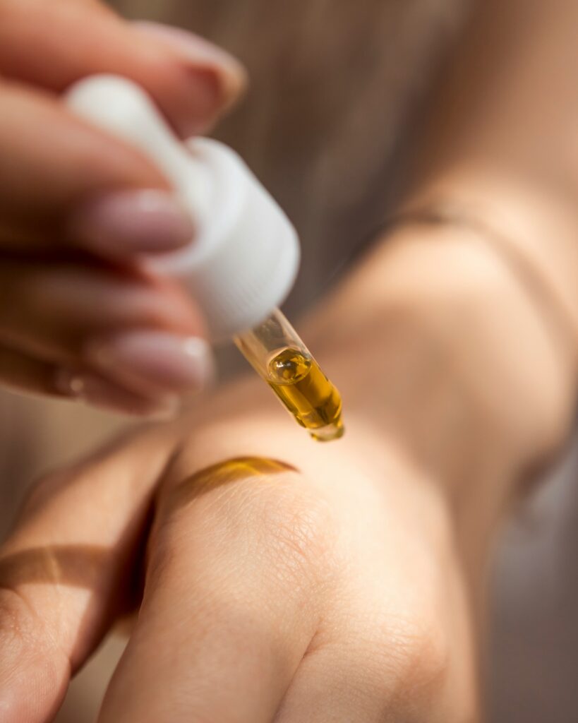 Close up of hand squeezing a cosmetic dropper