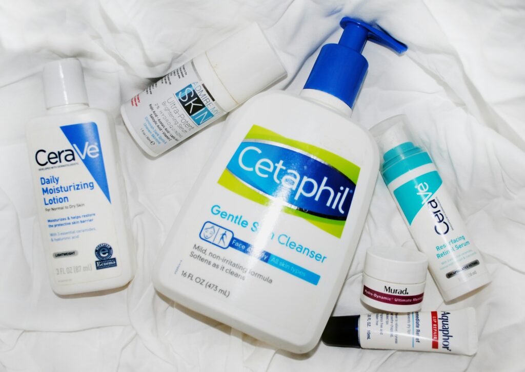 Various assorted face creams, lotions, and skincare products lay out on a white blanket